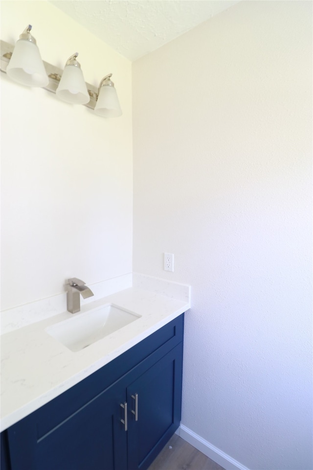 bathroom featuring a textured ceiling, vanity, and hardwood / wood-style flooring