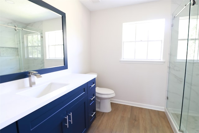 bathroom featuring hardwood / wood-style flooring, vanity, toilet, and a shower with door