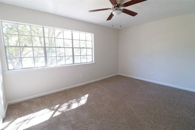 spare room featuring ceiling fan and carpet