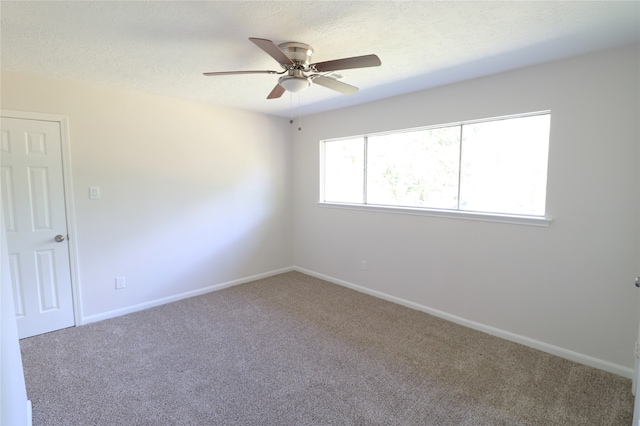 carpeted empty room with ceiling fan and a textured ceiling