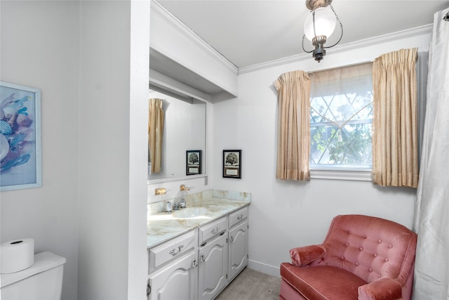 bathroom with crown molding, vanity, and toilet