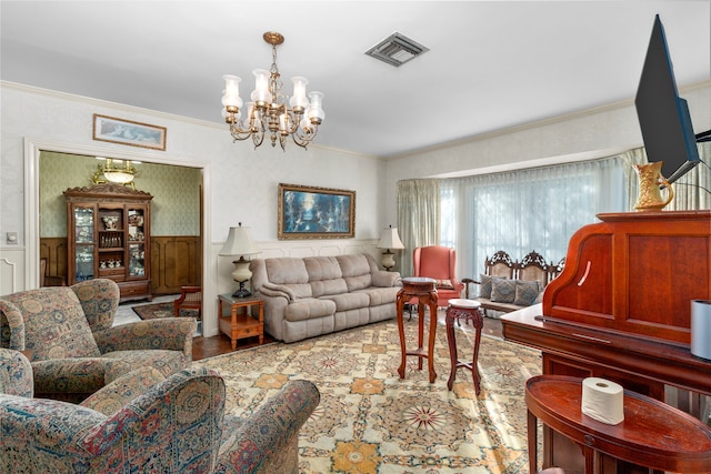 living room featuring ornamental molding, a notable chandelier, and wood-type flooring