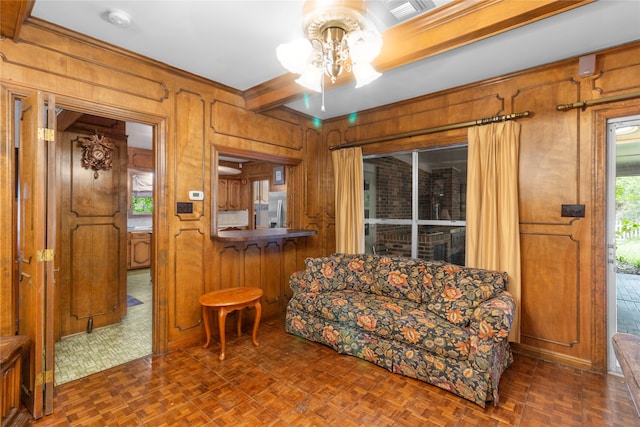 sitting room featuring dark parquet flooring, plenty of natural light, and wooden walls