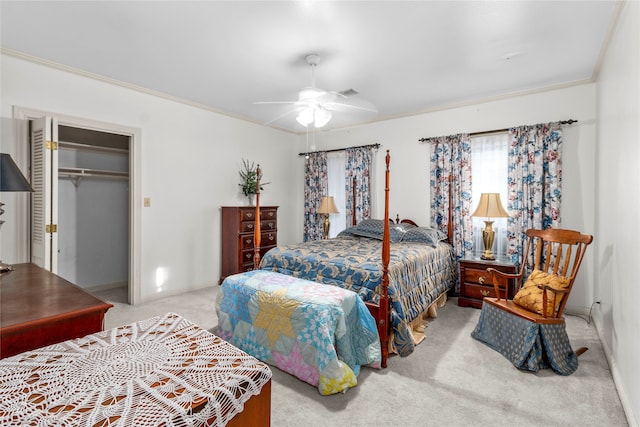 carpeted bedroom with a closet, ceiling fan, and ornamental molding