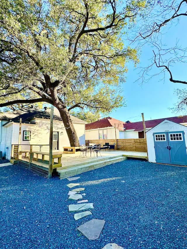 view of pool featuring a patio, a storage shed, and a wooden deck