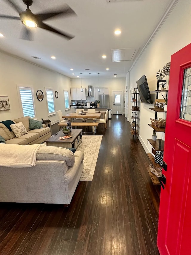 living room with ceiling fan, dark hardwood / wood-style flooring, and ornamental molding