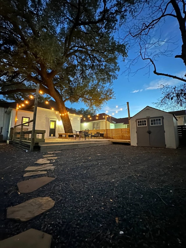 view of yard with a patio area, a deck, and a storage unit