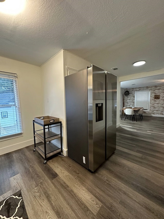 kitchen featuring stainless steel refrigerator with ice dispenser, a textured ceiling, and dark wood-type flooring