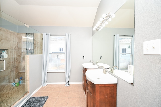 bathroom with tile patterned flooring, vanity, vaulted ceiling, and walk in shower