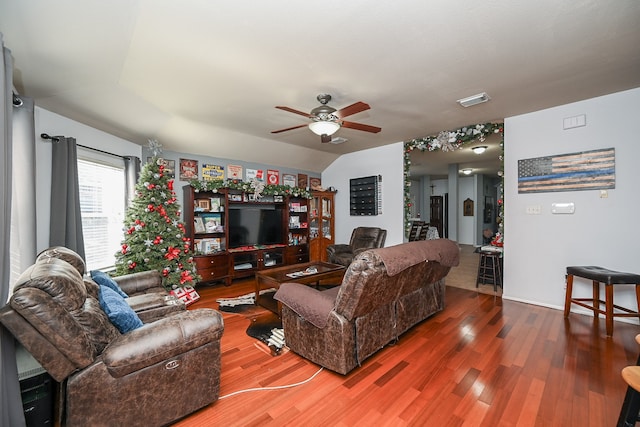 living room with ceiling fan, hardwood / wood-style floors, and vaulted ceiling