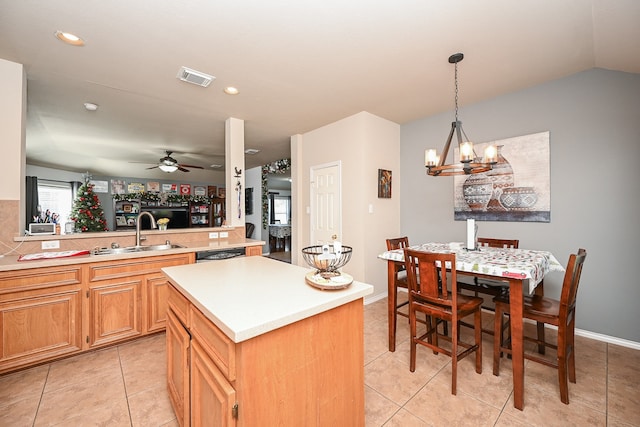 kitchen featuring kitchen peninsula, dishwashing machine, ceiling fan with notable chandelier, sink, and a center island