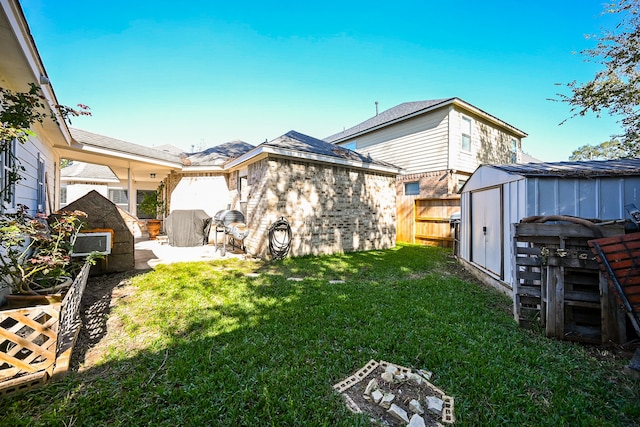 rear view of house featuring a yard, a patio, and a storage unit