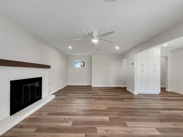 unfurnished living room featuring a fireplace, light wood-type flooring, and ceiling fan