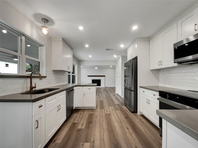 kitchen featuring stainless steel appliances, white cabinetry, and sink