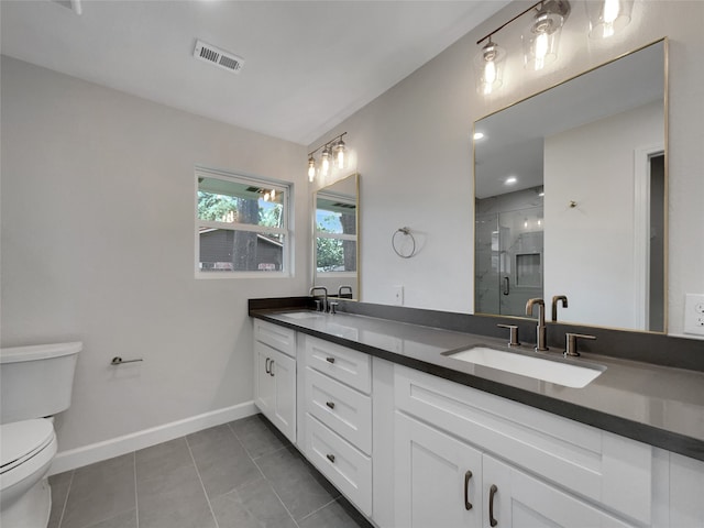 bathroom featuring tile patterned flooring, vanity, a shower with door, and toilet