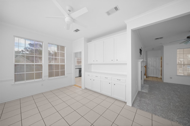 kitchen with white cabinets, light colored carpet, and ceiling fan