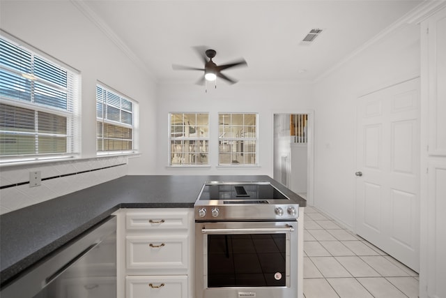 kitchen with white cabinets, appliances with stainless steel finishes, ornamental molding, and a healthy amount of sunlight