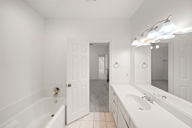 bathroom with tile patterned flooring, vanity, and a bath