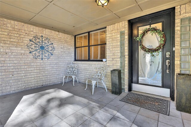 view of exterior entry featuring brick siding