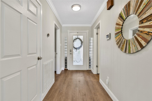 interior space with visible vents, a textured ceiling, crown molding, and wood finished floors