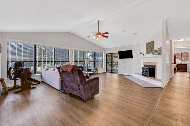 living area featuring visible vents, vaulted ceiling with beams, baseboards, light wood-type flooring, and a ceiling fan