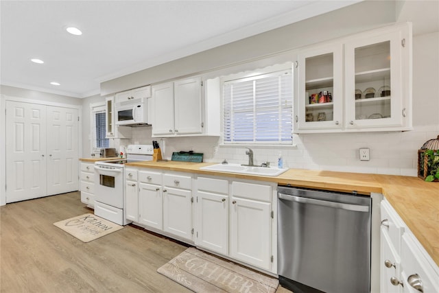 kitchen with wood counters, white appliances, white cabinetry, and a sink