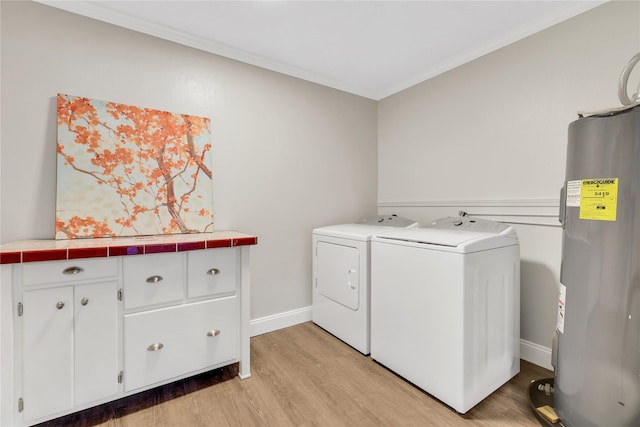 clothes washing area with light wood finished floors, cabinet space, separate washer and dryer, water heater, and crown molding