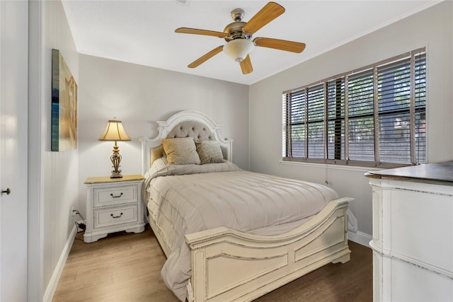 bedroom featuring light wood finished floors, ceiling fan, and baseboards