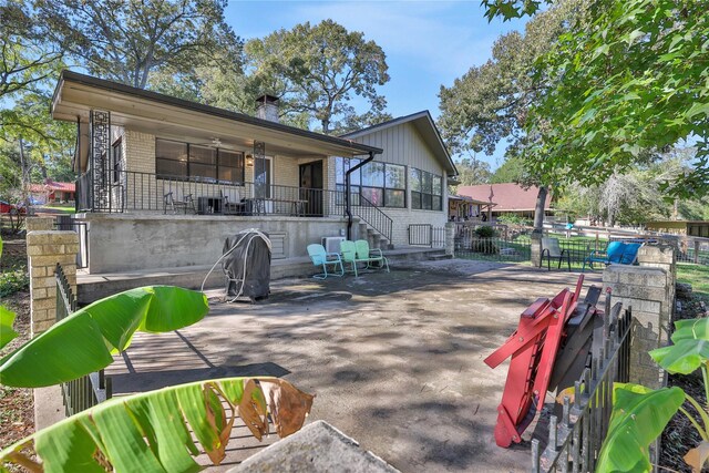 back of property featuring a patio, brick siding, a chimney, and fence