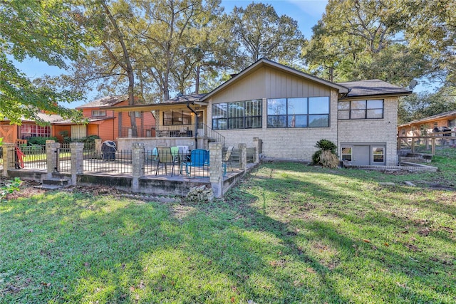 rear view of property featuring a patio area, a lawn, brick siding, and fence