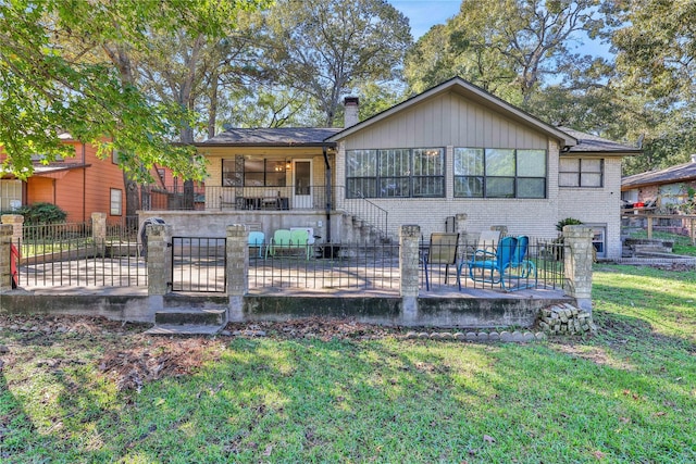 rear view of property with a patio, fence, a yard, brick siding, and a chimney