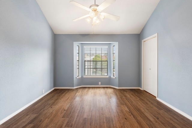 empty room featuring ceiling fan, dark hardwood / wood-style flooring, and vaulted ceiling