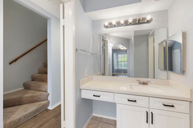 bathroom with wood-type flooring, vanity, and ceiling fan