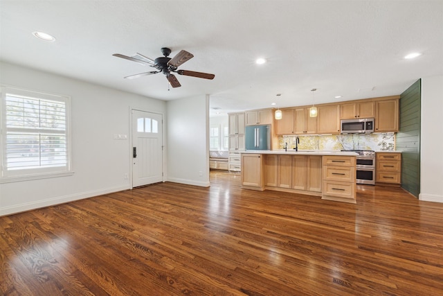 kitchen featuring sink, hanging light fixtures, ceiling fan, appliances with stainless steel finishes, and dark hardwood / wood-style flooring