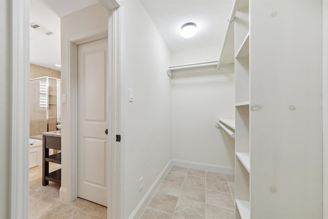 walk in closet featuring light tile patterned flooring