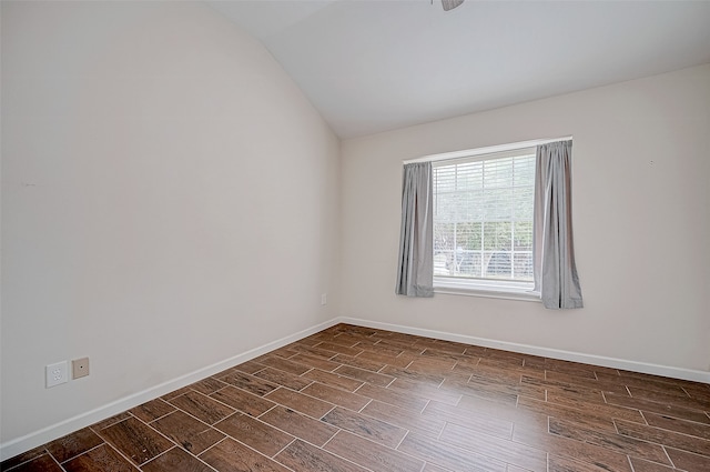 spare room with lofted ceiling and dark wood-type flooring