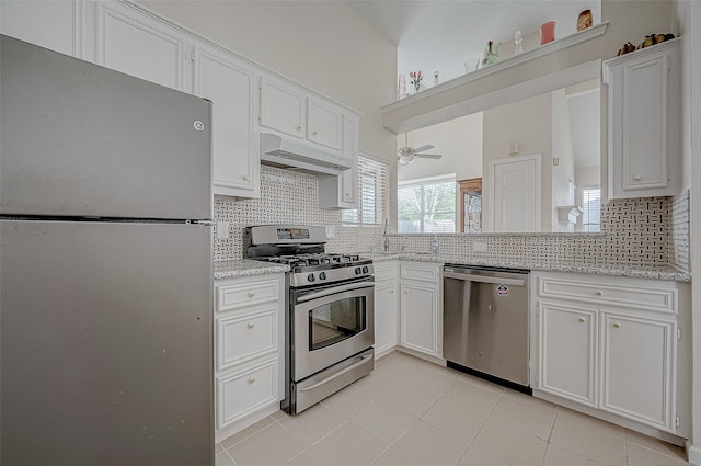 kitchen featuring white cabinets, stainless steel appliances, tasteful backsplash, and light tile patterned flooring