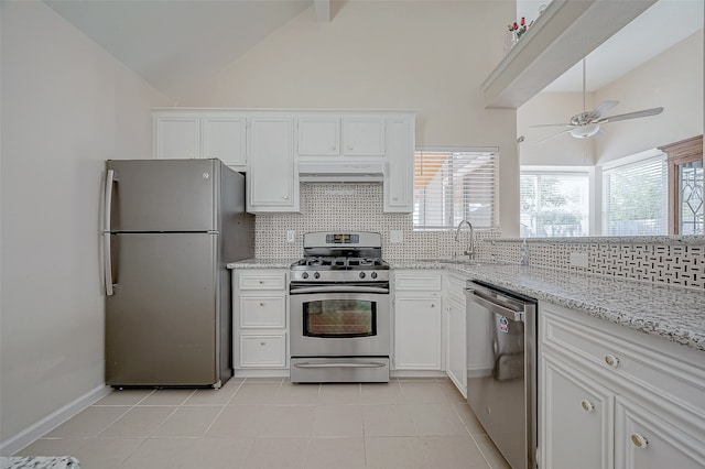 kitchen with sink, stainless steel appliances, light stone counters, decorative backsplash, and white cabinets