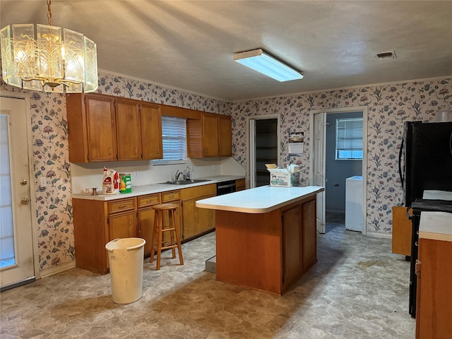 kitchen with sink, an inviting chandelier, pendant lighting, a textured ceiling, and a kitchen island