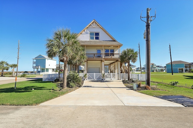 view of front of home with a front lawn, covered porch, and a garage