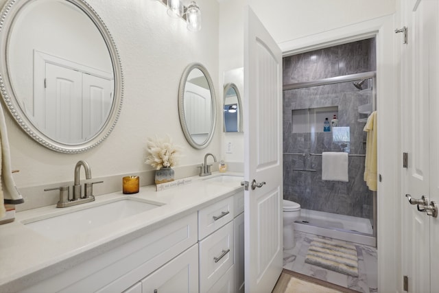 bathroom with tiled shower, vanity, and toilet