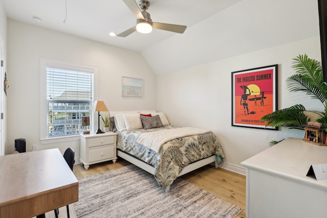 bedroom featuring ceiling fan, light hardwood / wood-style floors, and lofted ceiling