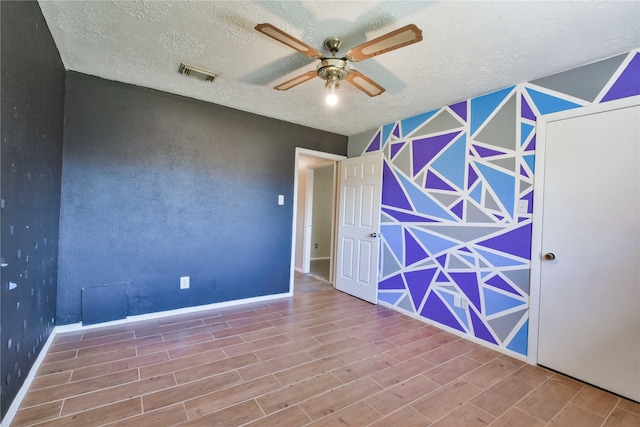 spare room with a textured ceiling, hardwood / wood-style flooring, and ceiling fan