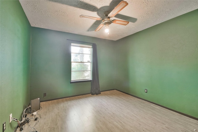 empty room with ceiling fan, light hardwood / wood-style floors, and a textured ceiling