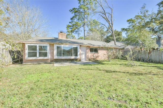 rear view of house featuring a yard and a patio area