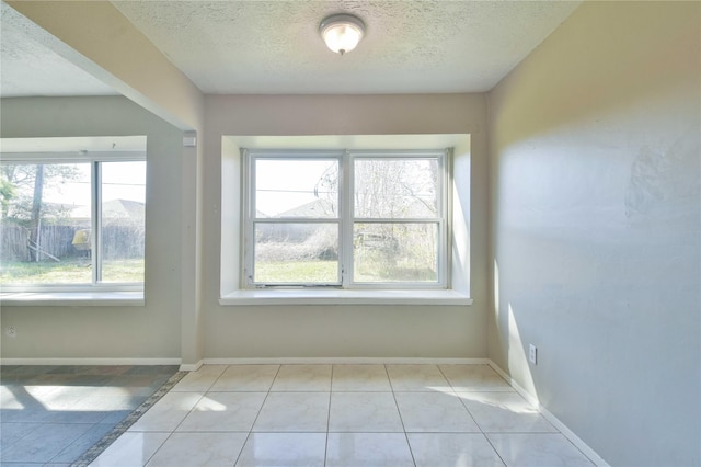 tiled spare room with a textured ceiling