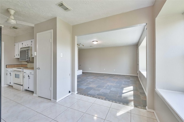 kitchen with ceiling fan, light tile patterned floors, white range oven, a textured ceiling, and white cabinets