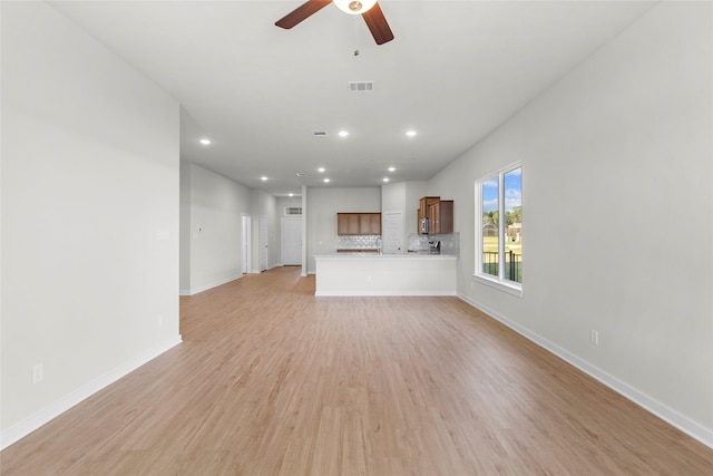 unfurnished living room featuring ceiling fan and light hardwood / wood-style floors