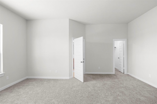 unfurnished room featuring light colored carpet