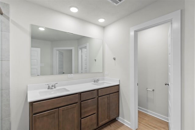 bathroom with hardwood / wood-style flooring, vanity, and a textured ceiling